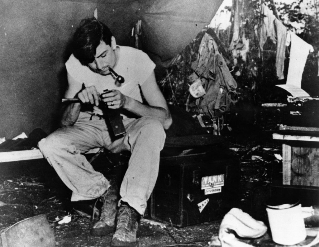 Bushemi cleans his equipment in makeshift quarters, somewhere in the Pacific