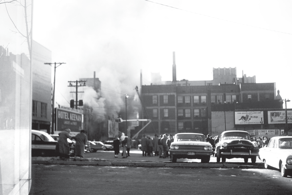 A crowd of people watches a fire at the Wolf and Dessauer department store.