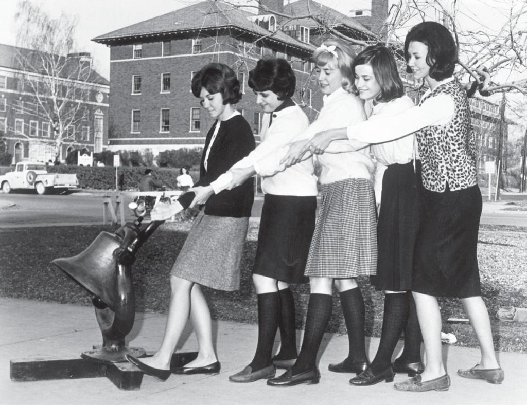 A group of five female students ring the Monon Bell on the Depauw campus.