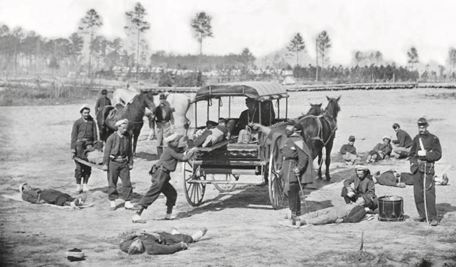 Civil War soldiers loading the wounded into a carriage served as an ambulance