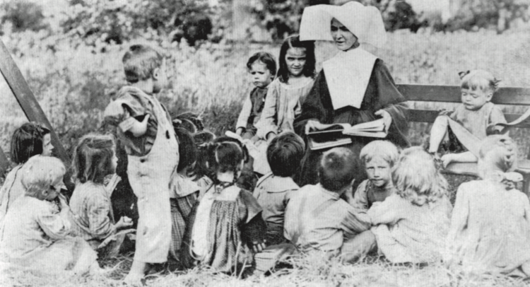 A woman from the Daughters of Charity reads to a group of children