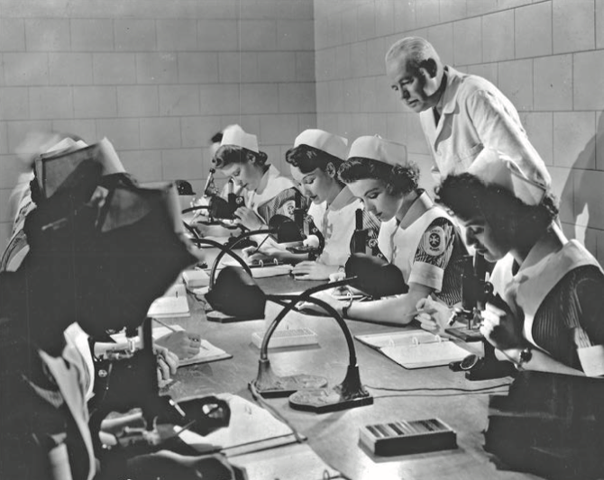 A still from a short film about cadet nurses showing young women taking a practice exam