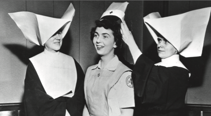 An image of two nurses awarding an American Red Cross volunteer her cap for completing a training program