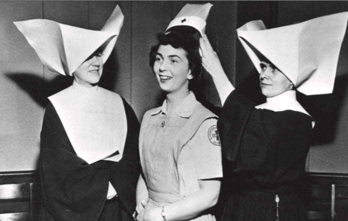 Capping Ceremony, Marillac Hall, c. 1955. An image of two nurses awarding an American Red Cross volunteer her cap for completing a training program