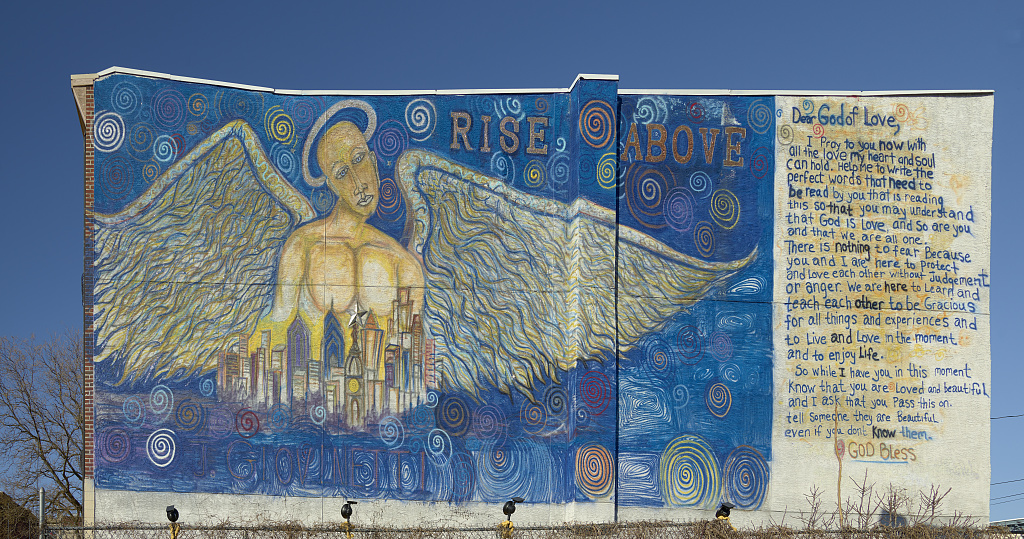 The "Rise Above" mural depicting an angel looking over the city with a letter to the God of Love next to it