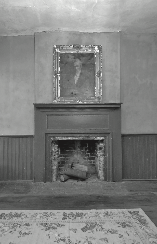 A photo of a fireplace with a portrait above it, located in the upstairs of the Hiram Haines Coffee and Ale House