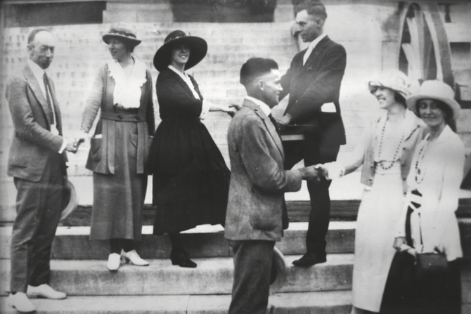 Harry T. Burn and other officials shaking hands with suffragettes on the steps of the state capitol