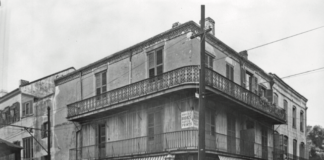A black and white photo of a building on a street corner