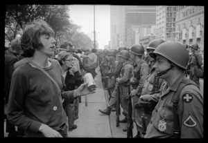 Photo of protestor standing in front of police