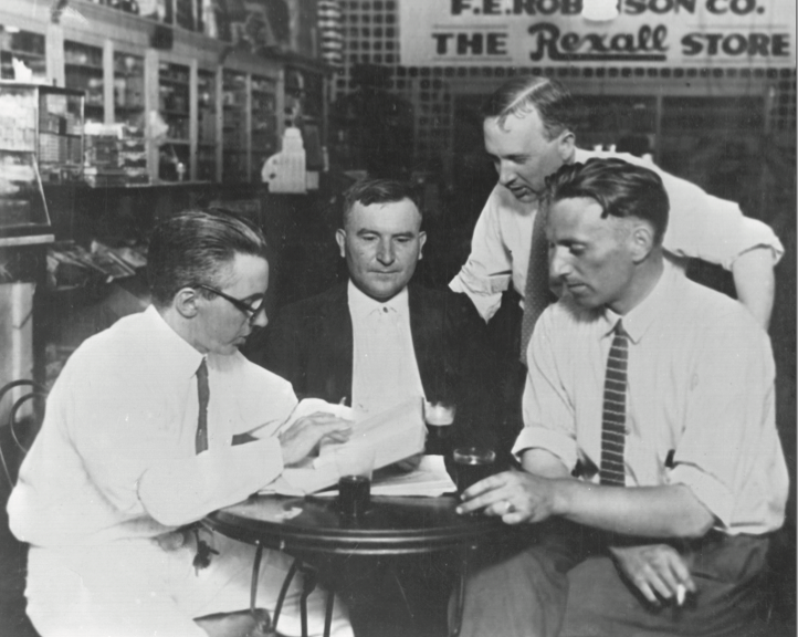 Four businessmen sitting and drinking around a small table