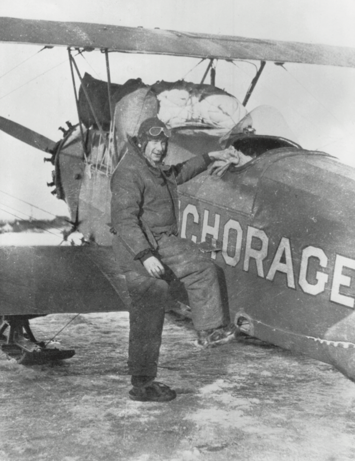 Russell Merrill posing next to his bi-plane