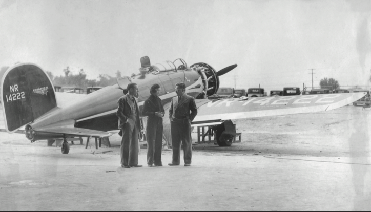 Billy Parker, Laura Ingalls, and Wiley Post inspect Laura’s Lockheed Orion in Bartlesville at the municipal airport.