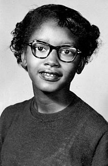 Portrait of a smiling Claudette Colvin in a sweater and glasses