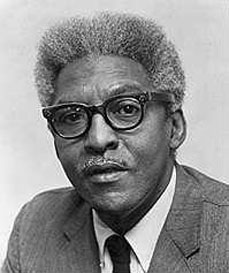 Portrait of Bayard Rustin in a suit and glasses