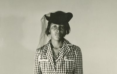 Recy Taylor in a checkered blazer and black netted hat