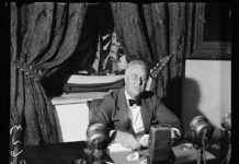 FDR sitting at a desk broadcasting on the radio