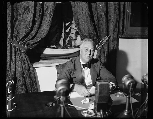 FDR sitting at a desk broadcasting on the radio