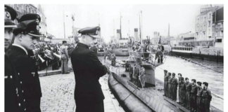 Karl Donitz and other Nazi look down at U-boat in the water