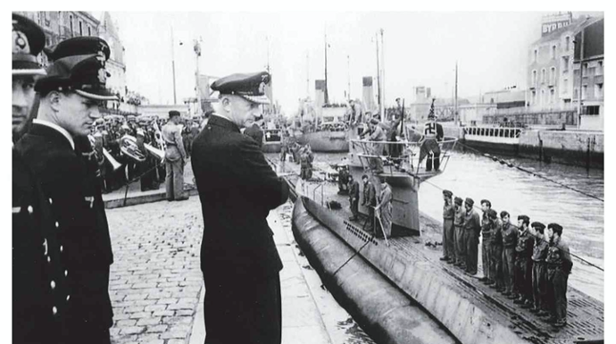 Karl Donitz and other Nazi look down at U-boat in the water